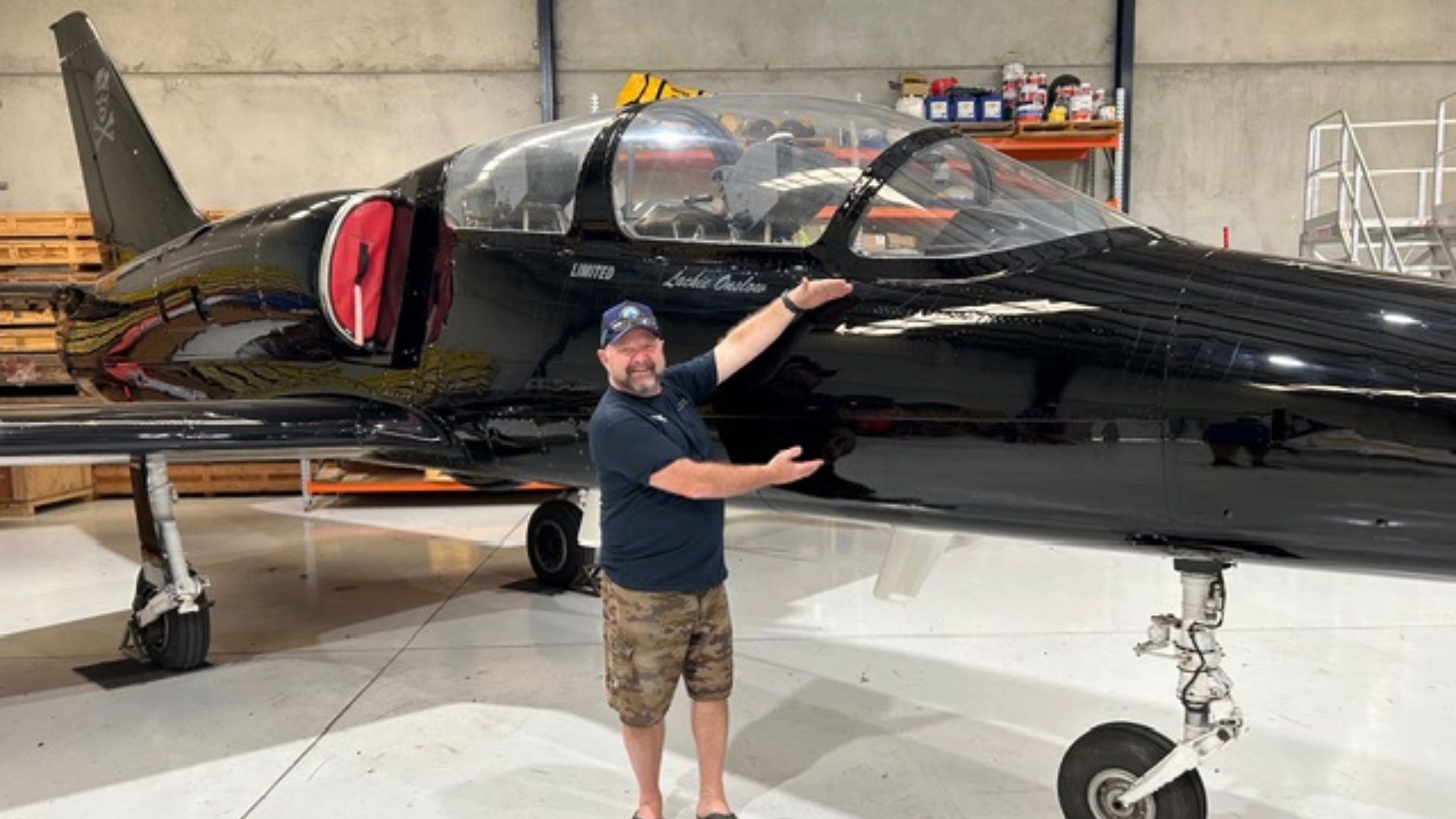 Warren Hamm smiling with energy and enthusiasm in front of a jet aircraft